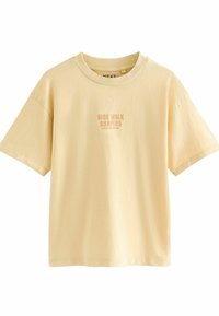 T-shirt jaune à manches courtes avec un col rond et un graphique "SIDE WALK SURFERS" imprimé dans une teinte légèrement plus foncée. Tissu doux, coupe décontractée.
