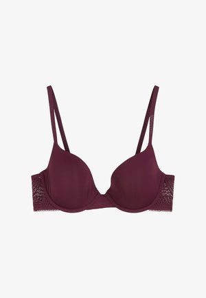 Soutien-gorge mauve avec armatures, dotée de bonnets lisses et rembourrés, et d'un panneau latéral en dentelle avec des motifs géométriques. Des bretelles réglables viennent parfaire le design.