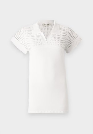 Valkoinen lyhythihainen poolopaita, jossa on teksturoitu yläosa ja sileä alaosa. Suunniteltu klassisella kauluksella ja V-aukolla.