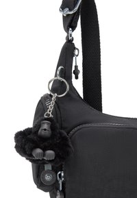 Sort nylon skuldertaske med en struktureret overflade, der har en lynlåslomme og en sort gorilla nøgleanhænger. Metal hardware detaljer er inkluderet.