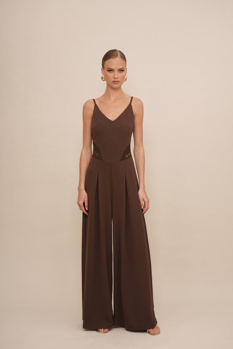 Jumpsuit marrón con escote en V, tirantes finos, paneles de encaje en los laterales y diseño de pierna ancha. Textura suave, estilo minimalista.