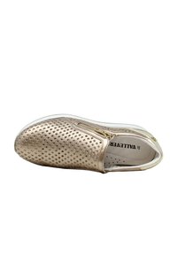 Scarpa slip-on metallizzata oro con design perforato, suola bianca e zip laterale. Fodera interna con pois e nome del marchio.