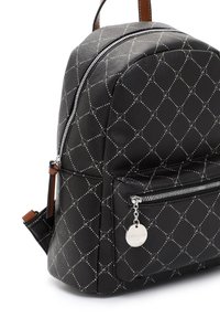 Musta nahkainen reppu, jossa harmaa geometrinen kuvio, edessä vetoketjutasku hopeanvärisellä vetoketjulla ja pyöreällä merkkillisellä vetoketjun vedolla.