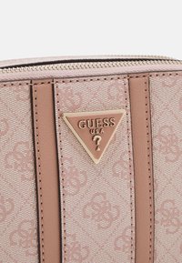 Borsa a tracolla in tessuto rosa con motivo logo impresso, accentuata da pelle beige liscia, hardware dorato e chiusura zip.