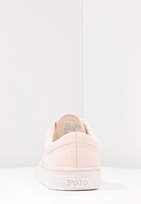 Růžové plátěné tenisky s bílými akcenty, gumovou podrážkou a značenou patou. Zadní pohled ukazuje minimální detaily šití.