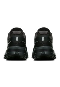 Schwarze Laufschuhe mit einem strukturierten Obermaterial aus Textil und dicken Gummisohlen. Verfügt über ein Logo und reflektierende Akzente an der Ferse und an den Seiten.