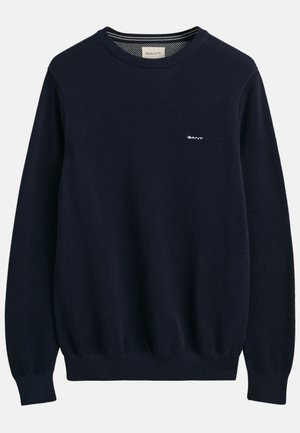 Pullover in maglina blu navy con un motivo testurizzato, scollo rotondo, polsini e orlo a coste, con un piccolo logo bianco sul petto.