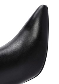 Zwarte hooggehakte schoen met een puntige neusontwerp, voorzien van een gladde, gestructureerde synthetische leren bovenkant en een slanke silhouette.