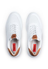 Białe sneakersy z siateczki i skóry, okrągły czubek, płaskie sznurowadła oraz beżowy akcent na pięcie. Widoczna czerwona metka wewnątrz.