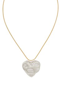 Guldkedja med en glänsande, vit hjärtformad berlock med en slät yta och organiska ytdetaljer.