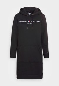 Schwarzes Hoodie-Kleid aus weichem Stoff, mit einer Fronttasche, verstellbarem Kapuzenzug und weißem, gesticktem Logo auf der Brust.