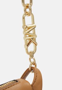 Brauner Lederhandtaschenriemen mit goldfarbener Metallhardware, ausgestattet mit einem Logo-Verschluss und einem abgerundeten Befestigungspunkt. Glatte Textur mit Reißverschlussdetails.