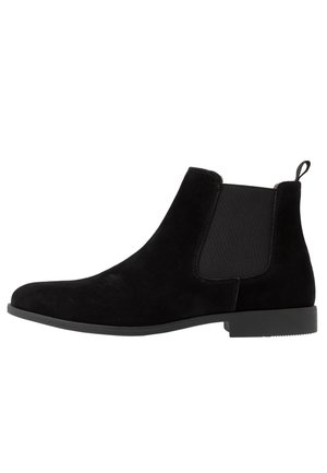 Bottine Chelsea en daim noir avec panneaux latéraux élastiques, languette au talon et petit talon bloc.