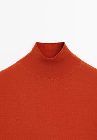 Oranger Strickpullover mit hohem Kragen, geripptem Kragen, glatter Textur und sattem, warmem Farbton auf weißem Hintergrund.