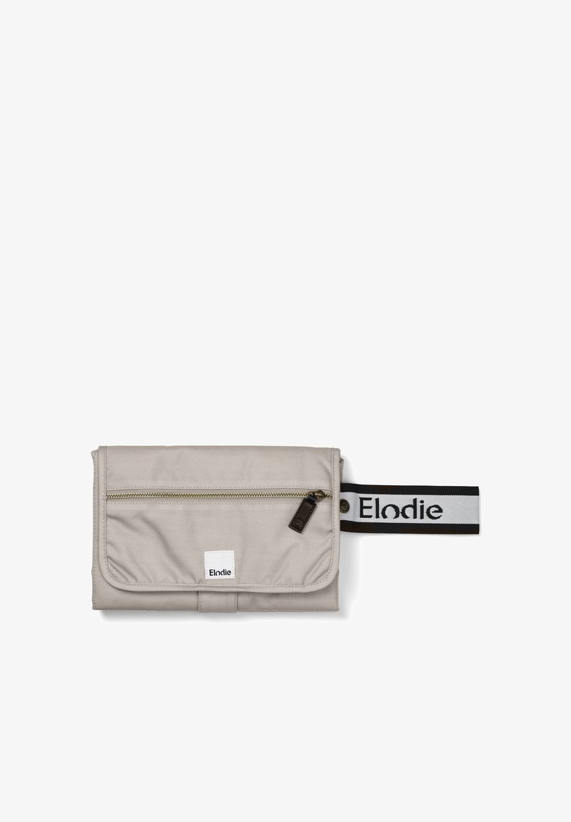 Beige tygpåse med en dragkedjeförsedd framficka, ett svart och vitt randigt band, och en vit logotyp-patch. Slät textur, rektangulär form.