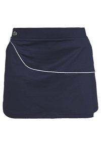 Mörkblå sportkjol i texturerat tyg med en vit accentlinje längs framsidan och en liten grön logotyp vid midjan.