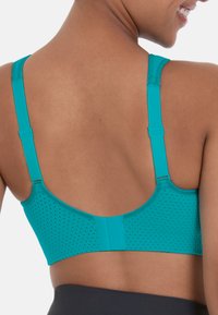 Teal urheilusisälsyö, jossa on tekstuuri ja rei'itetty muotoilu. Säädettävät hihnat, sileä vyötärö ja saumaton selkä mukavuutta ja tukea varten.