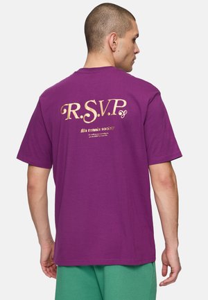 Paarse katoenen T-shirt met gouden tekst "R.S.V.P." en "fila tennis society" op de achterkant; korte mouwen en een ontspannen pasvorm.