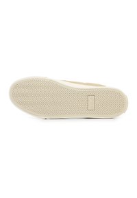 Sneaker outsole featuring a beige rubber surface with a herringbone pattern, rounded toe, and brand logo embossed near the heel.