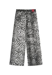 Leveälahkeiset mustavalkoiset housut, joissa on leopardikuvio ja teksturoitu pinta sekä vyötäröllä punainen etiketti.