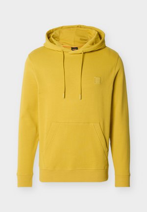 Żółta bluza z kapturem wykonana z bawełny, wyposażona w przednią kieszeń, kaptur z regulowanym sznurkiem, ściągacze przy rękawach oraz małą naszywkę z logo na piersi.