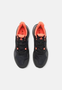 Scarpe da ginnastica nere con superficie testurizzata, dettagli arancioni vivaci e lacci neri. Presentano un collo imbottito e una fodera in rete traspirante.
