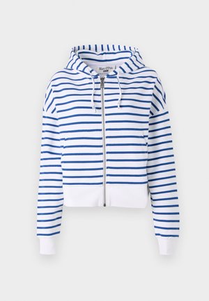 Valgest kangast lühikeste varrukatega tõmblukuga kapuutsiga sviiter, millel on sinised horisontaalsed triibud. Omab reguleeritavat kapuutsi ja soonikkoes aanet, et mugavust lisada. Pehme puuvillane materjal.