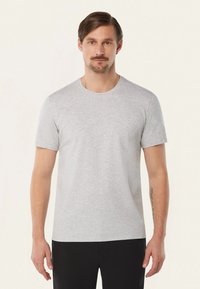 Grijze t-shirt met korte mouwen in een zachte katoenmix, voorzien van een ronde kraag en een minimalistisch ontwerp, gecombineerd met zwarte broeken.