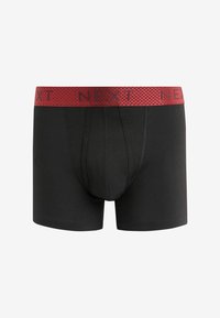 Fekete boxer alsónadrág piros elasztikus derékpánttal, amelyen a "NEXT" márkajelzés található. Simító anyagból készült, Fazonos kialakítással és elülső zsebből.