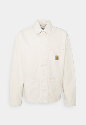 Veste de travail écrue avec fermeture à boutons devant, trois poches avant dont une poche poitrine avec un petit patch logo de la marque.