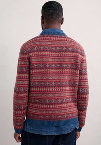 Maglione lavorato a maglia con un motivo geometrico rosso e blu; presenta un colletto in denim blu e polsini e orlo a coste; materiale in misto lana.