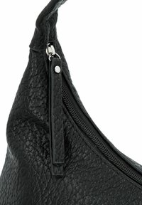 Schwarze Lederhandtasche mit taktilem Besatz, Reißverschluss und geschwungenem Design. Verfügt über einen abnehmbaren Riemen und Metallakzente.