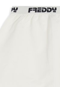 Pantalones cortos de color crema con cintura elástica que presenta "FREDDY" en negro. Textura suave, diseño casual, detalles fruncidos en la cintura.