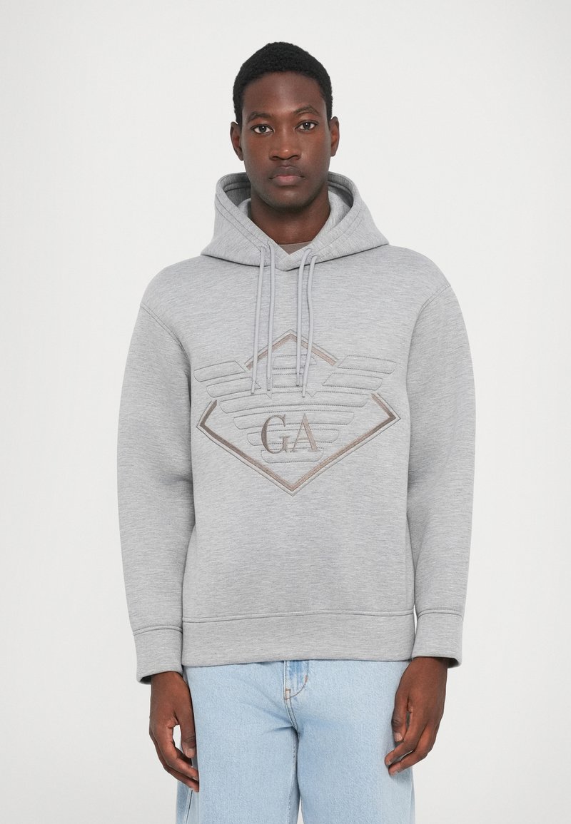 Grijze hoodie met een diamanten logo met vleugels en "GA" in bruin. Gemaakt van zacht materiaal, heeft het een ontspannen pasvorm en verstelbare koordjes.
