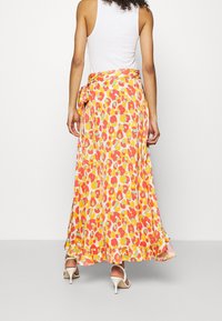 Gonna maxi fluida e colorata con un vivace motivo floreale nei colori rosa, giallo e verde. Presenta una vita con cordoncino e orlo arricciato.