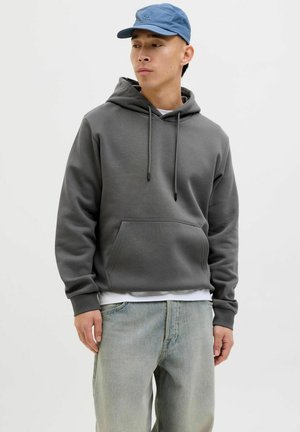 Hooded sweatshirt in dark gray cotton blend, featuring a front kangaroo pocket, drawstrings, and ribbed cuffs. Worn with light blue jeans.