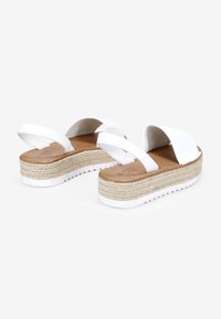 Sandalias de plataforma blancas con suela de yute trenzado, tira frontal ancha y diseño de parte trasera abierta. Acabado suave con plantilla en tono bronce.