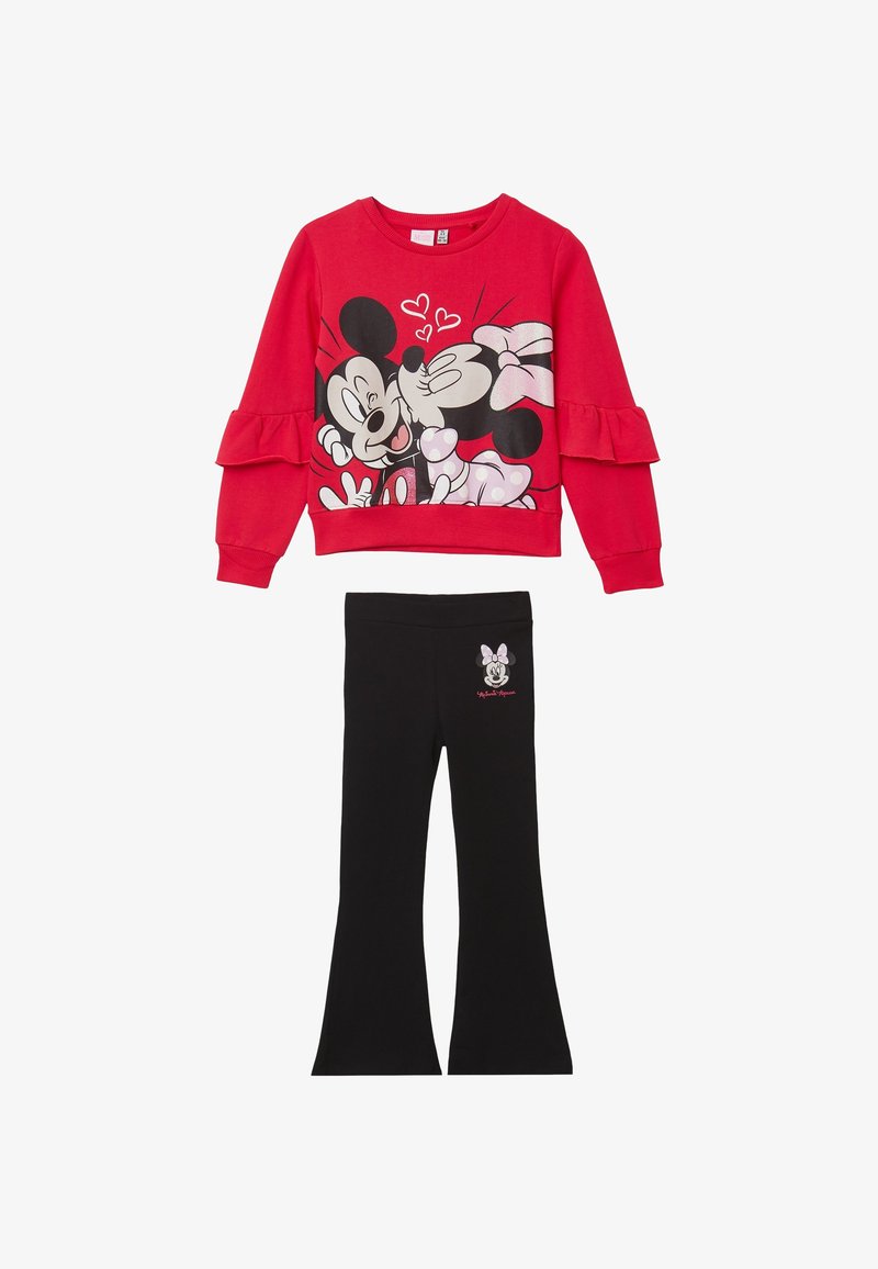 Top rosso a maniche lunghe con grafica di Topolino e Minni, e pantaloni neri a zampa d'elefante con un piccolo disegno di Minni sull'anca.