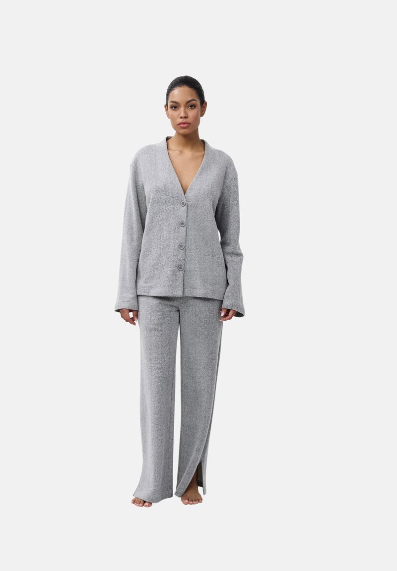 Grijze gebreide lounge-outfit bestaande uit een diepe V-hals cardigan met knopen en wijde broekspijpen met sleuven aan de onderkant. Zachte textuur.