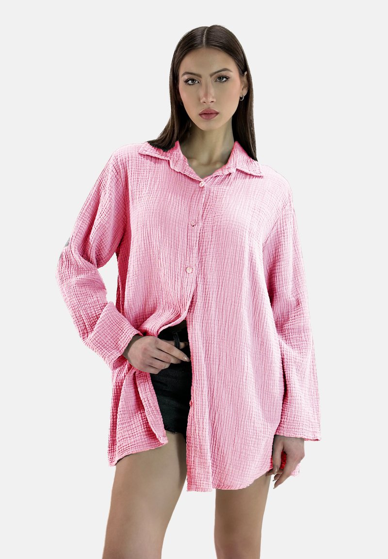 Roze, gestructureerde overhemd met kraag en lange mouwen, met een kreukelige afwerking en een relaxed fit. Zwarte shorts eronder gedragen.