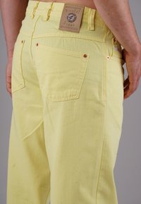 Yellow jeans made of cotton, with a straight cut, featuring back pockets, contrast stitching, and a leather tag detailing "Picaldi."