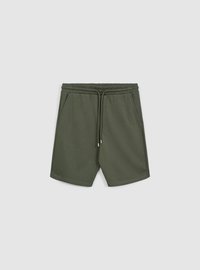 Pantaloncini verdi in tessuto strutturato, dotati di una cintura elastica con coulisse e tasche laterali. Lunghezza standard e design casual.