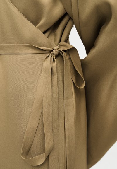 Vêtement en tissu marron avec une ceinture nouée à la taille et des manches longues et amples.