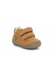 Chaussure pour tout-petit en cuir tan présentant deux bandes velcro, une semelle en caoutchouc à finition texturée et un accent logo vert près de la cheville.
