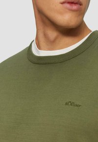 Olivgrüner Rundhalsausschnitt-Pullover aus weichem Material, mit einem gerippten Kragen und einem kleinen, auf der Vorderseite gestickten s.Oliver-Logo.