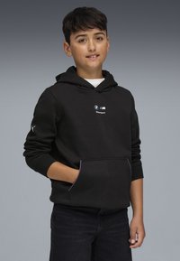 Sudadera negra con bolsillo tipo canguro, con el logo de BMW Motorsport y acentos en rojo y azul a lo largo del bolsillo y los puños. Material suave de mezcla de algodón.