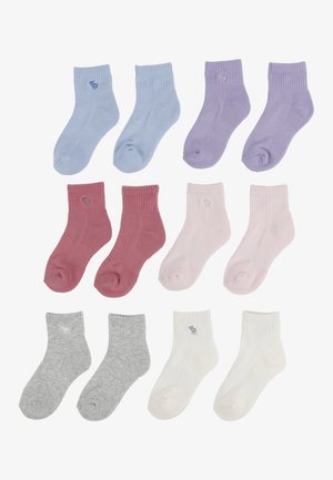 Chaussettes en coton assorties de couleurs pastel : bleu, lavande, rose, bordeaux, gris et blanc ; design côtelé ; chacune avec un petit détail de logo.