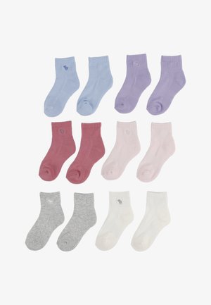 Chaussettes en coton assorties de couleurs pastel : bleu, lavande, rose, bordeaux, gris et blanc ; design côtelé ; chacune avec un petit détail de logo.