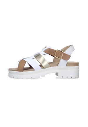 Sandali bianchi in pelle con accenti dorati e beige, caratterizzati da una suola bianca spessa, design open-toe e cinturino regolabile alla caviglia.