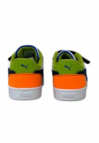 Zapatillas Puma con suela blanca, acentos vibrantes en verde y naranja, materiales texturizados y un logotipo azul en la parte trasera.